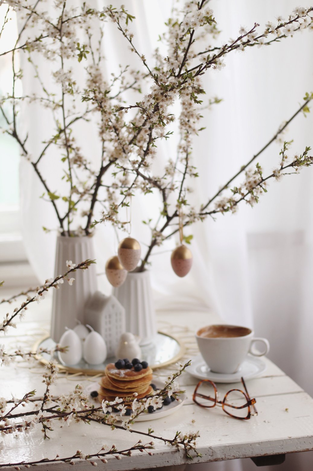 Pancakes near hanging decorative eggs